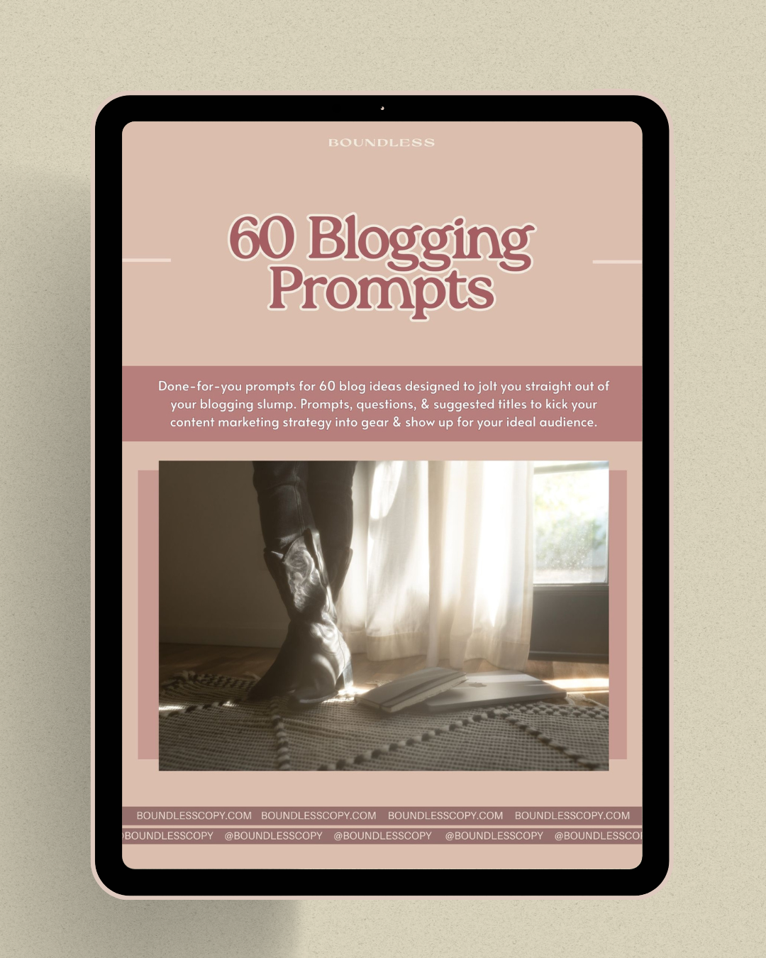 A tablet shows the cover photo for Boundless Copy's 60 Blogging Prompts resource.